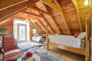 A high-ceilinged room with a wooden ceiling, a bed with a headboard, a chair, and a window. - Fire Pit, Deck! Rural Retreat Near East Beach (Charlestown)