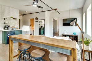 A modern kitchen with a coffee machine, a dining table with stools, and a ceiling fan. - Remodeled Getaway in the Heart of Mountain Home! (Mountain Home)