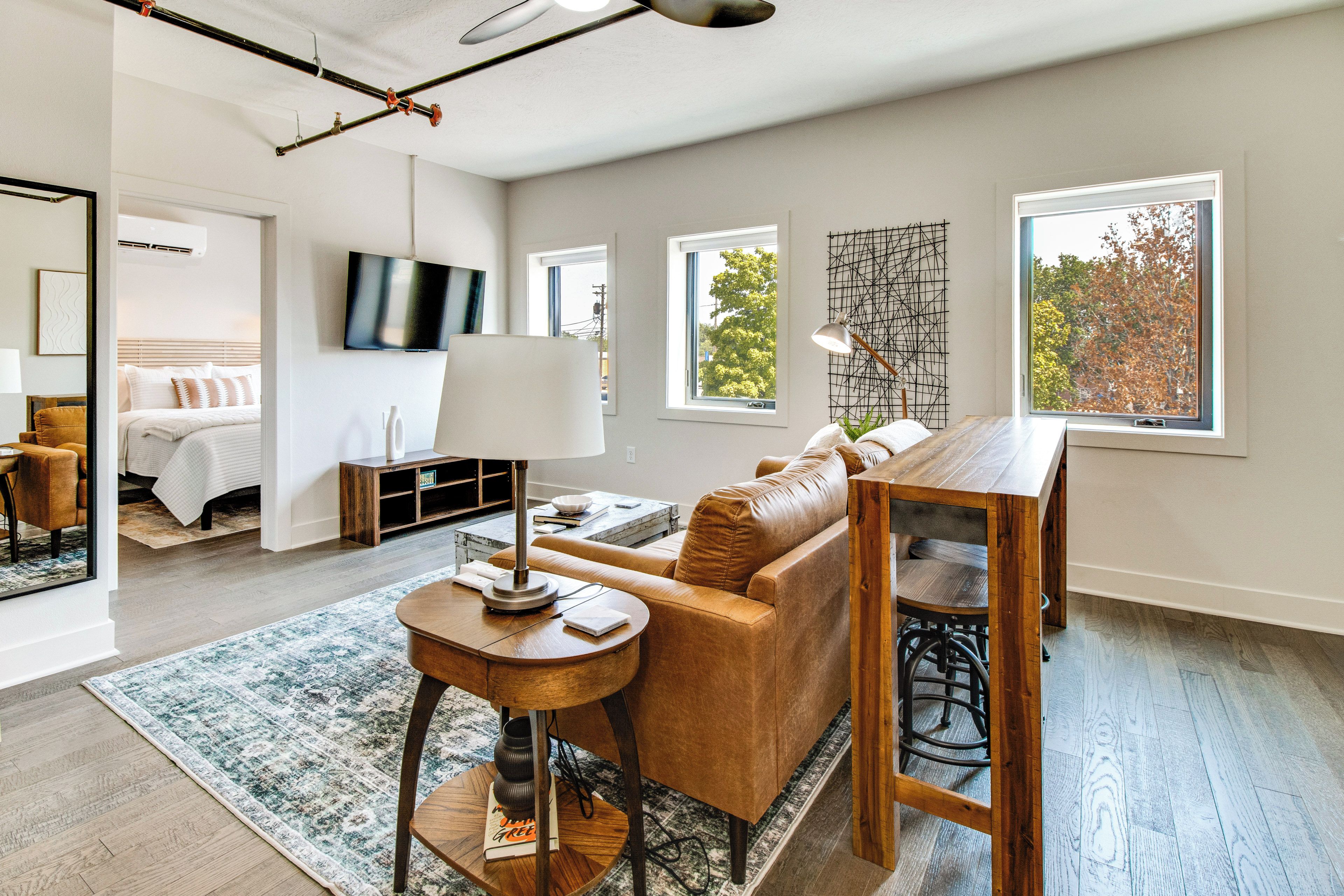 Una sala de estar moderna con un sofá, una mesa de centro y una zona de comedor con una mesa de madera y sillas.