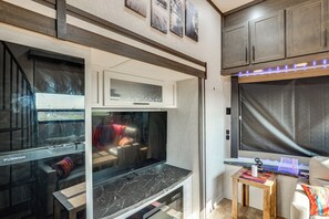 A modern living room with a large flat-screen TV, a fireplace, and a small wooden table.
