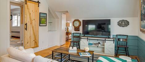 A cozy living room with a sofa, coffee table, and a TV.