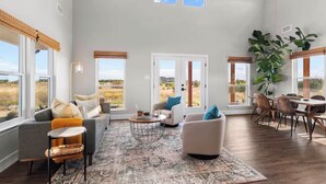 A spacious living room with a high ceiling, large windows, and a view of the outdoors. - Private Pickleball Court! Family Glen Rose Getaway (Glen Rose)
