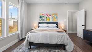 A bedroom with a bed, bedside tables, a ceiling fan, and artwork on the wall. - Private Pickleball Court! Family Glen Rose Getaway (Glen Rose)