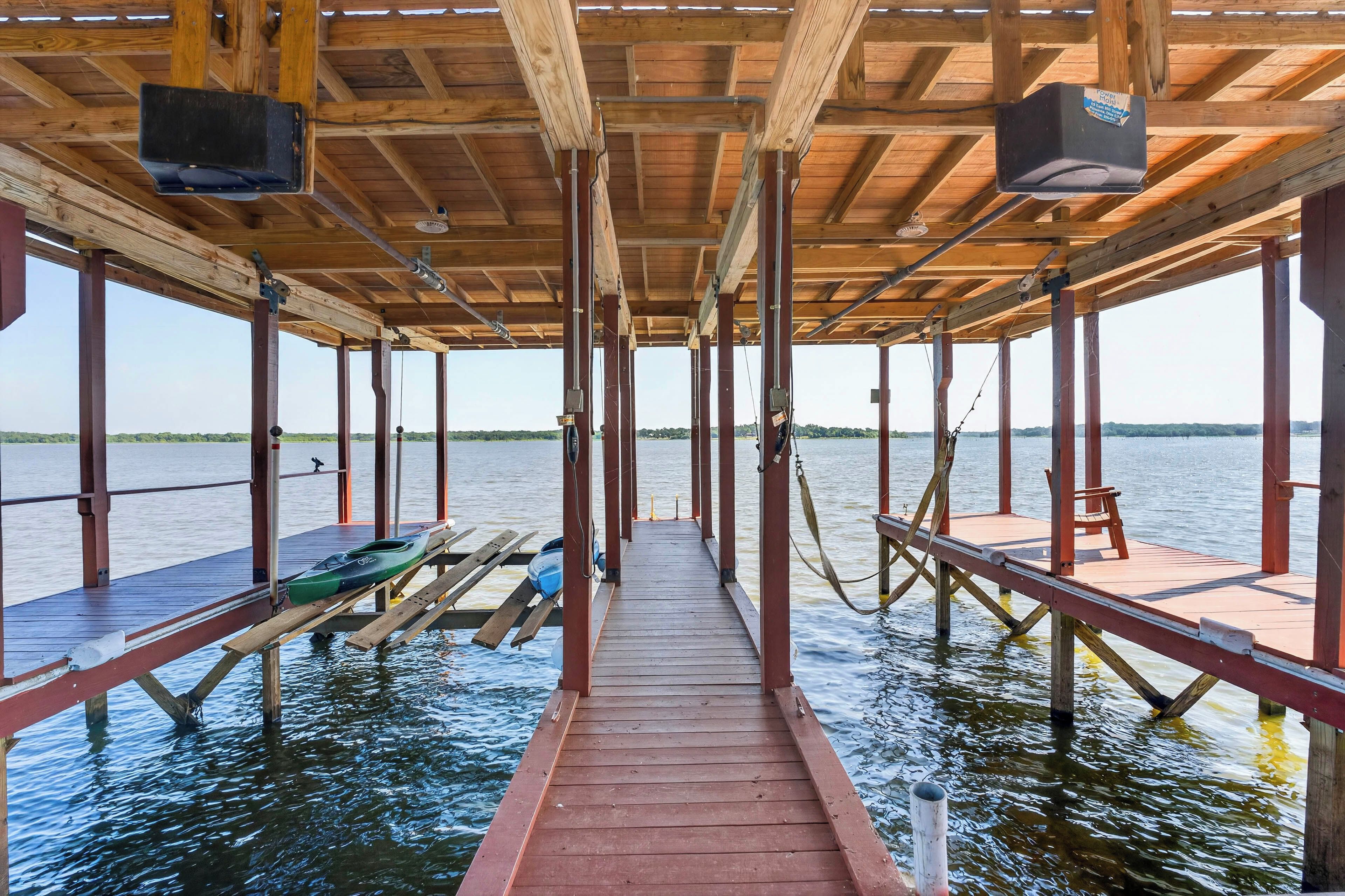 A wooden pier extending into a body of water with a clear view of the horizon.