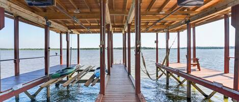 A wooden pier extending into a body of water with a clear view of the horizon.