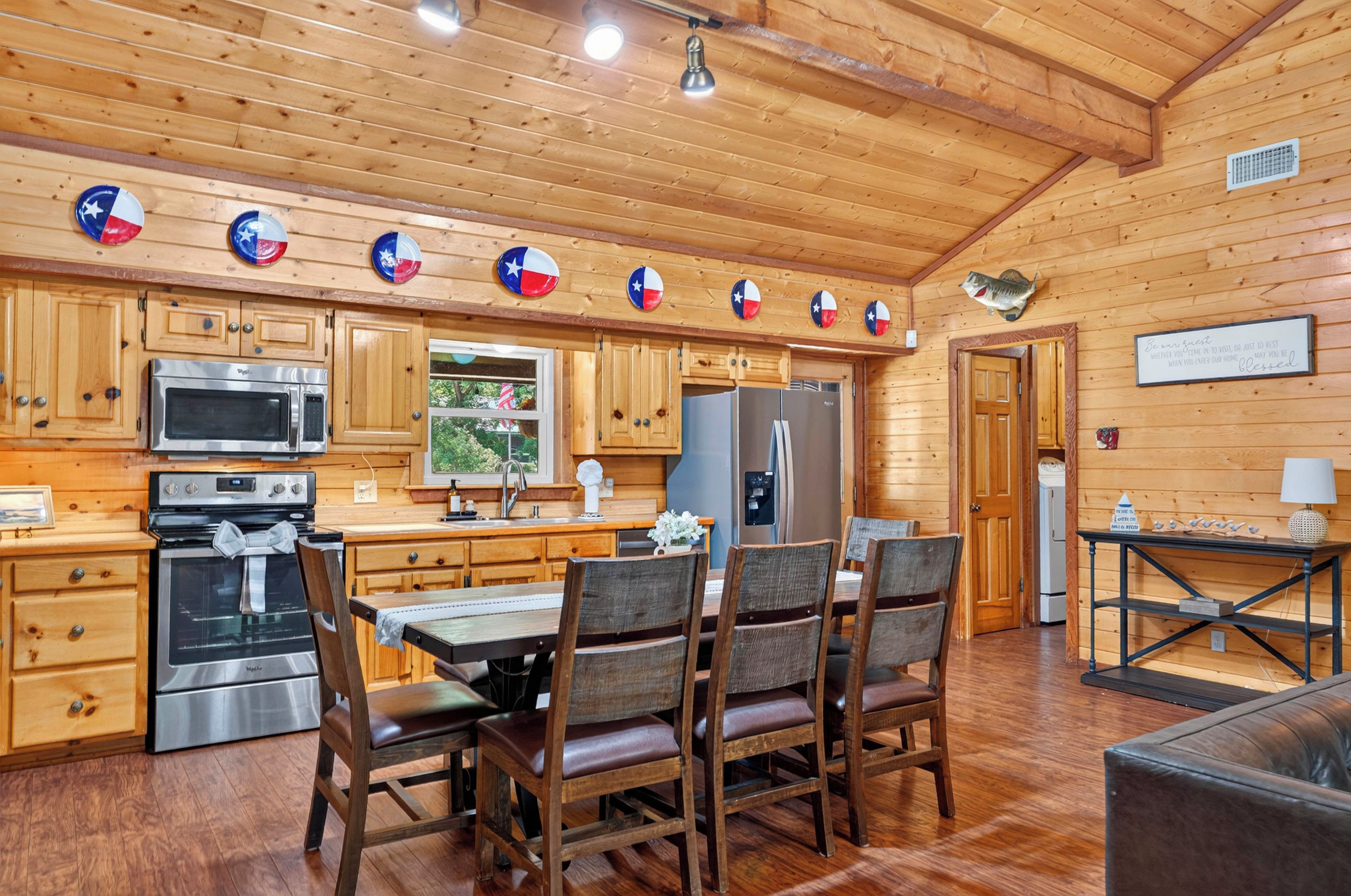 A wooden interior with a kitchen, dining area, and a guest room.