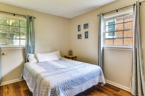 A bedroom with a bed, a nightstand, a window with curtains, and a wall with framed pictures. - 2 Mi to Csu, Lake Oliver & Airport! Home w/ Yard (Columbus)
