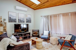 Una sala de estar acogedora con una televisión de pantalla plana, chimenea y asientos cómodos.