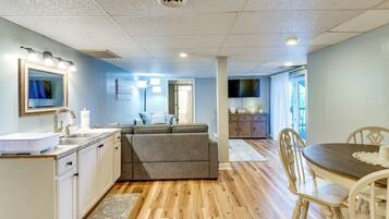 A modern kitchen with a sink, countertop, and overhead lighting.