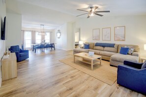 A spacious living area with a dining table, sofas, and a coffee table.