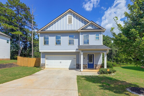 A two-story residential house with a garage, a front porch, and a driveway.