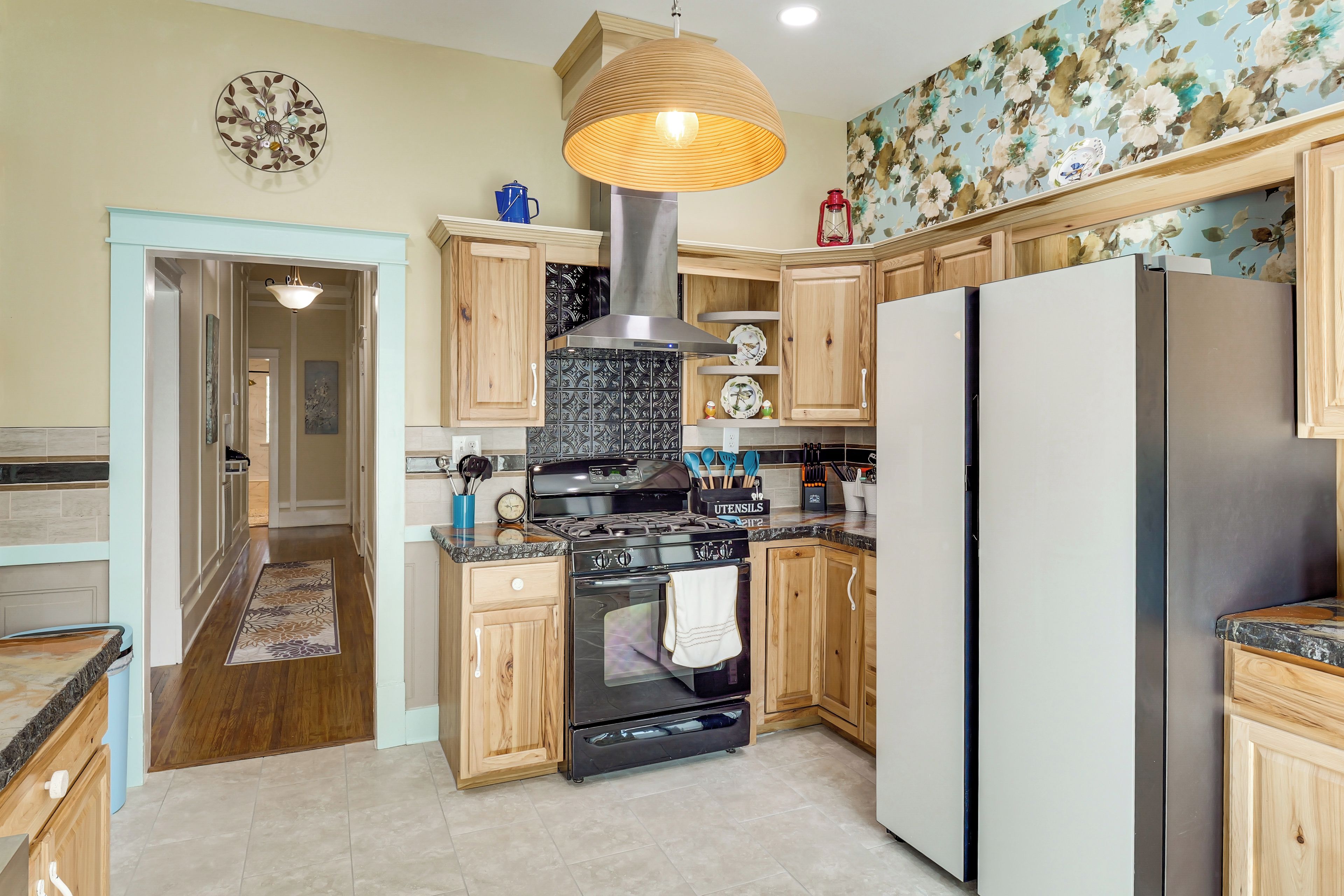 A modern kitchen with wooden cabinets, a stainless steel stove, and a large refrigerator.