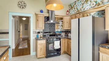 A modern kitchen with wooden cabinets, a stainless steel stove, and a large refrigerator.