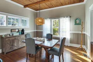 A dining area with a wooden table, four chairs, and a hanging light fixture. - 'feels Like Home' Quiet Home Near Wartrace Shops (Wartrace)