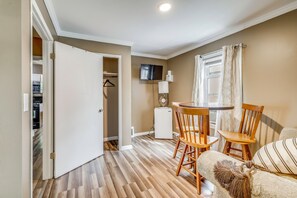 Un espacio habitable compacto con comedor, kitchenette y televisor en la pared.