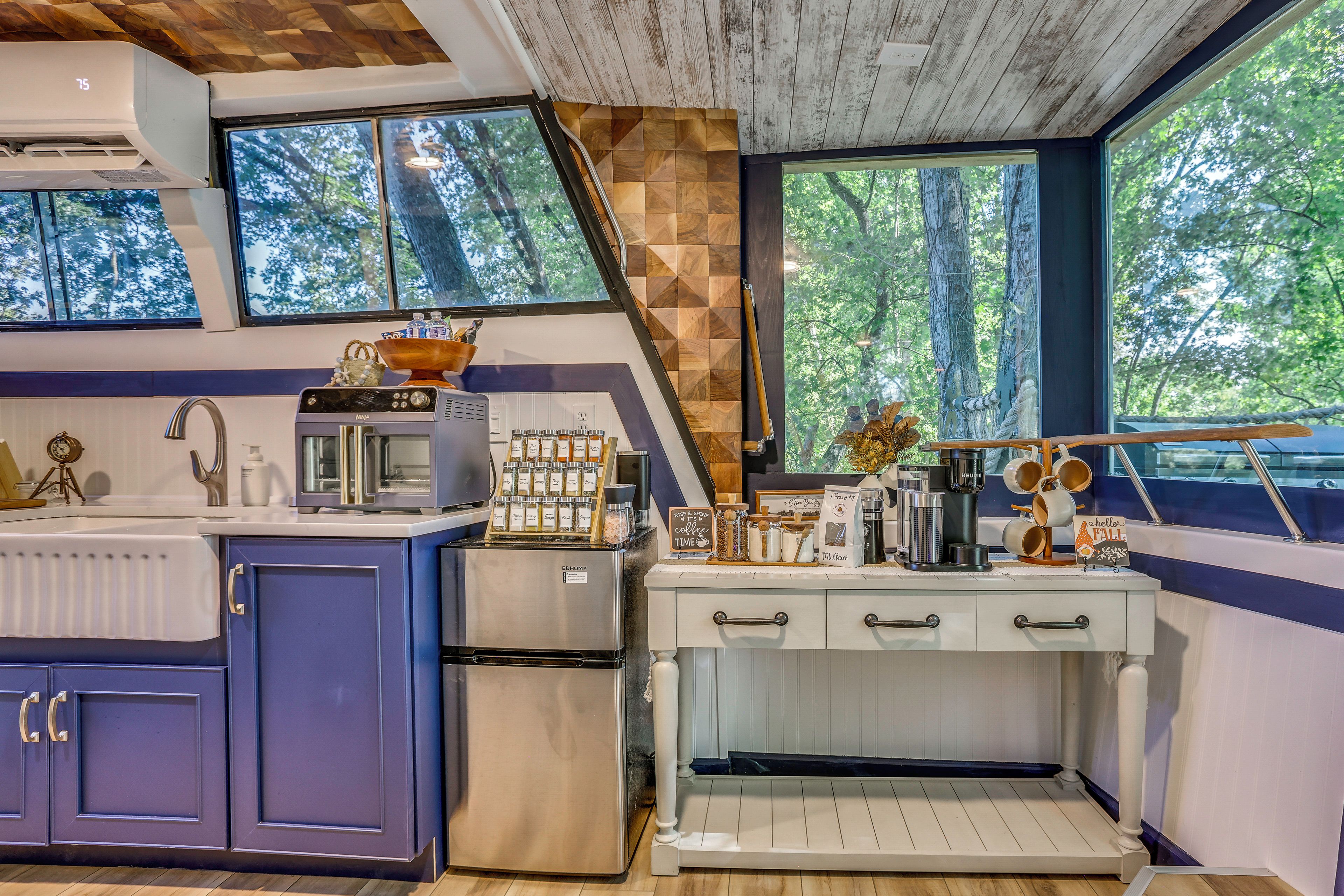 A modern kitchen with a built-in stove, a refrigerator, and a coffee station.