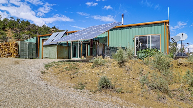 A modern house with solar panels, a large window, and a satellite dish. - Off-grid New Mexico Hideaway Off Hwy 60 (Pie Town)