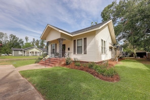 A single-story house with a front porch, a small front yard, and a garage.