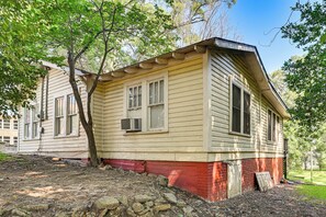 A two-story house with a red base and beige siding, featuring a small porch and a chimney. - Walk to Main St! Quaint Philadelphia Home w/ Yard (Philadelphia)