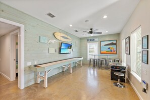 A beach-themed room with a pool table, bar area, and a ceiling fan. - No Agenda Hacienda | Private Pool, Game Room, Close to Beach! (Port Aransas)