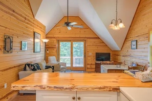 A cozy cabin interior with a wooden interior, a dining area, and a large window.