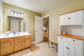 Une salle de bain avec un meuble-lavabo en bois, un miroir et un espace douche.