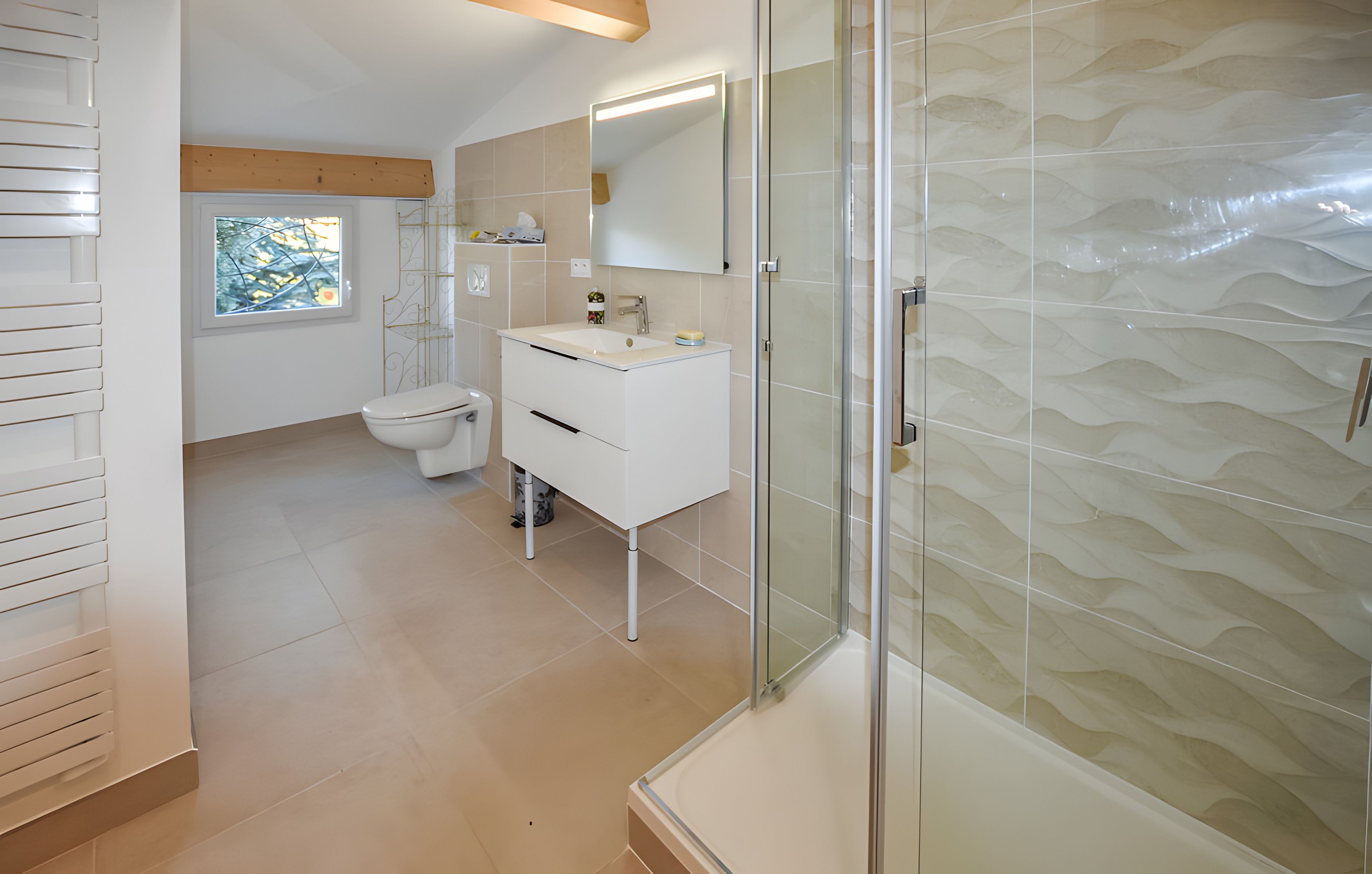 Ein modernes Badezimmer mit Duschkabine aus Glas, einem weißen Waschbecken und einer Toilette.