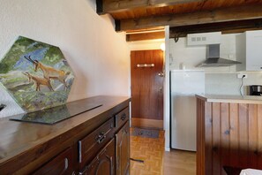 Una cocina de madera con un refrigerador blanco, un armario de madera y un cuadro de ciervos en la pared.