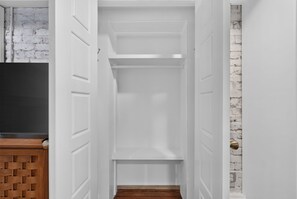A narrow hallway with white doors and a wooden floor. - Historic Garden Retreat in the Heart of Downtown Savannah with parking! (Savannah)