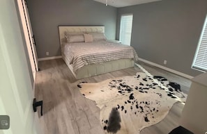 Une chambre à coucher avec un lit, une grande moquette et une fenêtre.