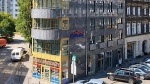 Edifício de vários andares com design moderno, apresentando um espaço comercial no térreo com vitrine aparente.
