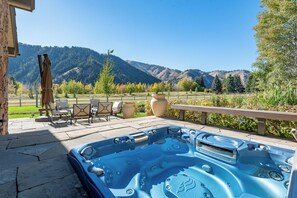 A hot tub with a view of mountains, outdoor seating, and a pergola. - Weyyakin Home 307- Amazing Home Minutes From Downtown & Skiing (Sun Valley)