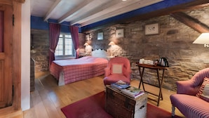A room with a bed, two chairs, a table, and a stone wall. - La Ferme de Sophie - Josepha Room (Kleingœft)