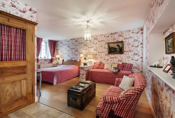Quarto com cama, sofá, cómoda, escrivaninha e abajur.
