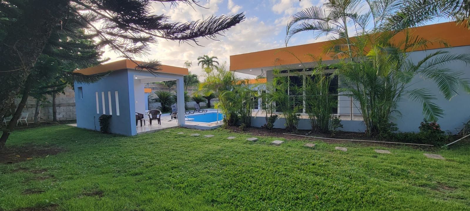 A modern building with a swimming pool and a small gazebo.