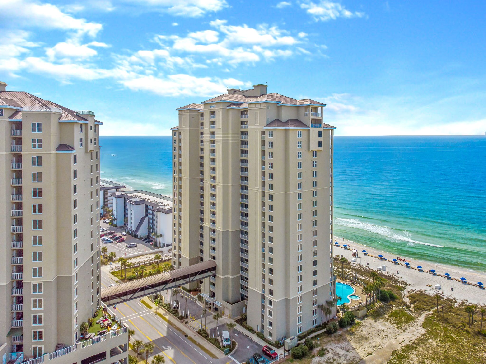 Hotel alto com várias varandas com vista para a praia e o oceano.