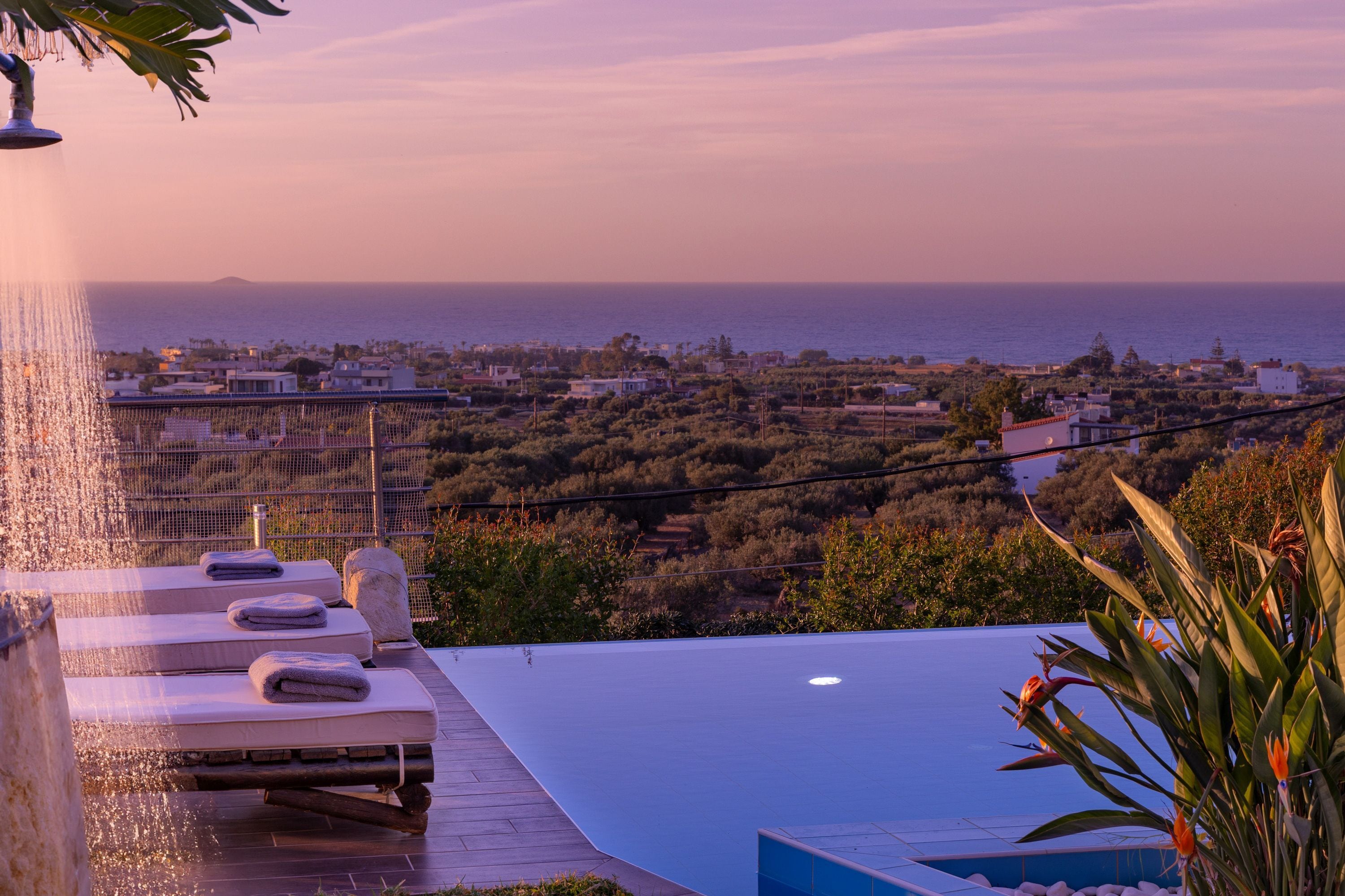 An infinity pool with a view of the sea and a cityscape.