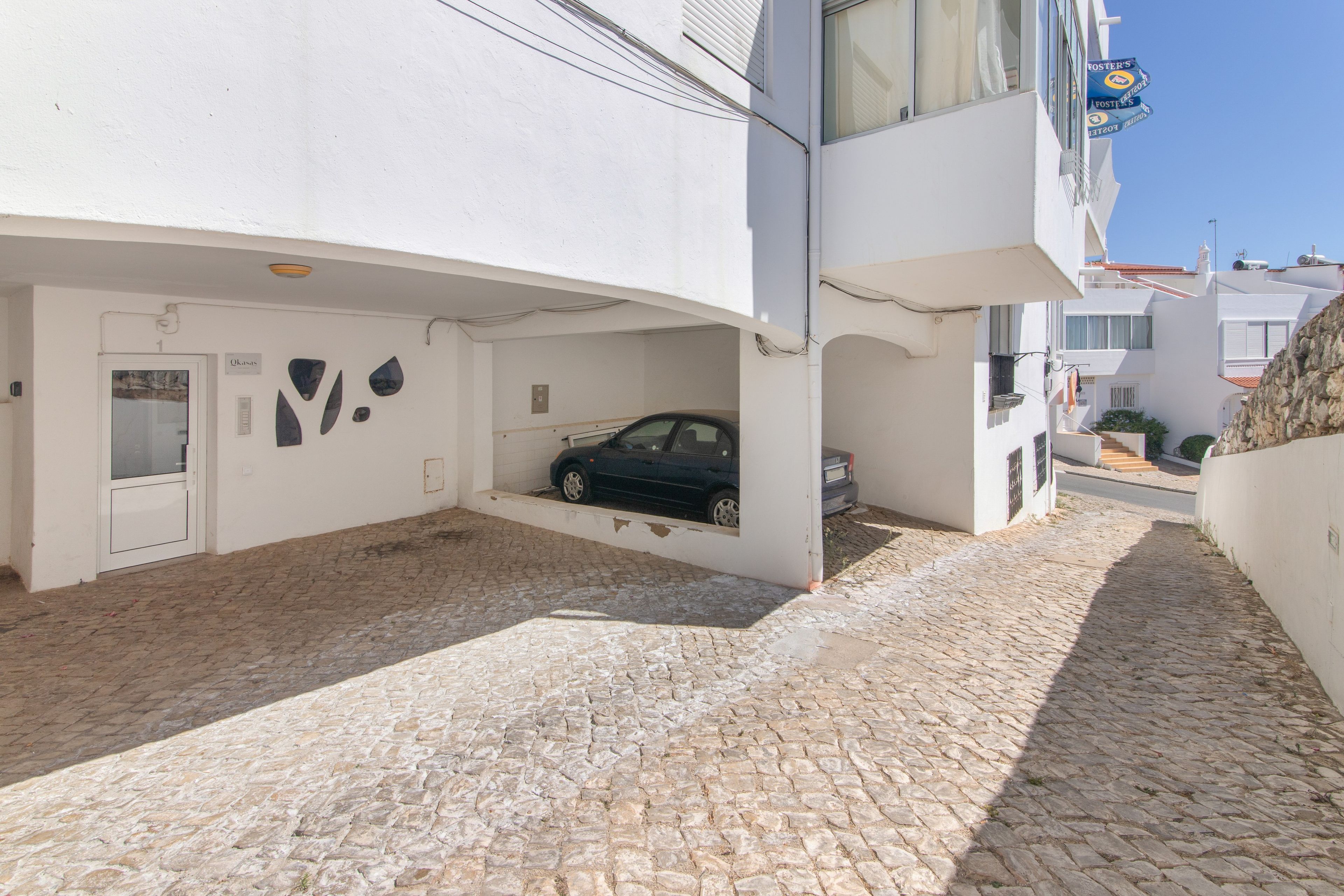 A building with a car parked in a covered parking area.