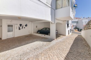 Um edifício com um carro estacionado em uma vaga coberta.
