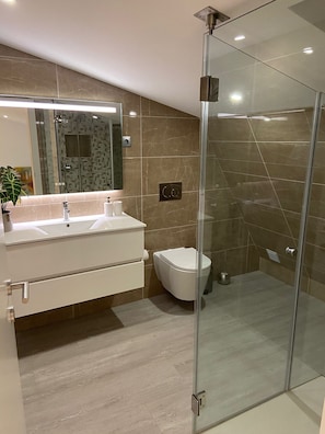 A modern bathroom with a glass shower enclosure, a white sink, and a toilet. - Holiday Home 'Old Town Charm' with Private Terrace, Wi-Fi and Air Conditioning (Albufeira)