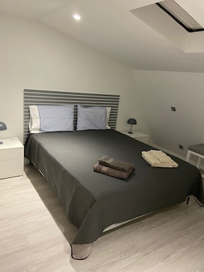 A modern bedroom with a bed, bedside tables, and a lamp. - Holiday Home 'Old Town Charm' with Private Terrace, Wi-Fi and Air Conditioning (Albufeira)