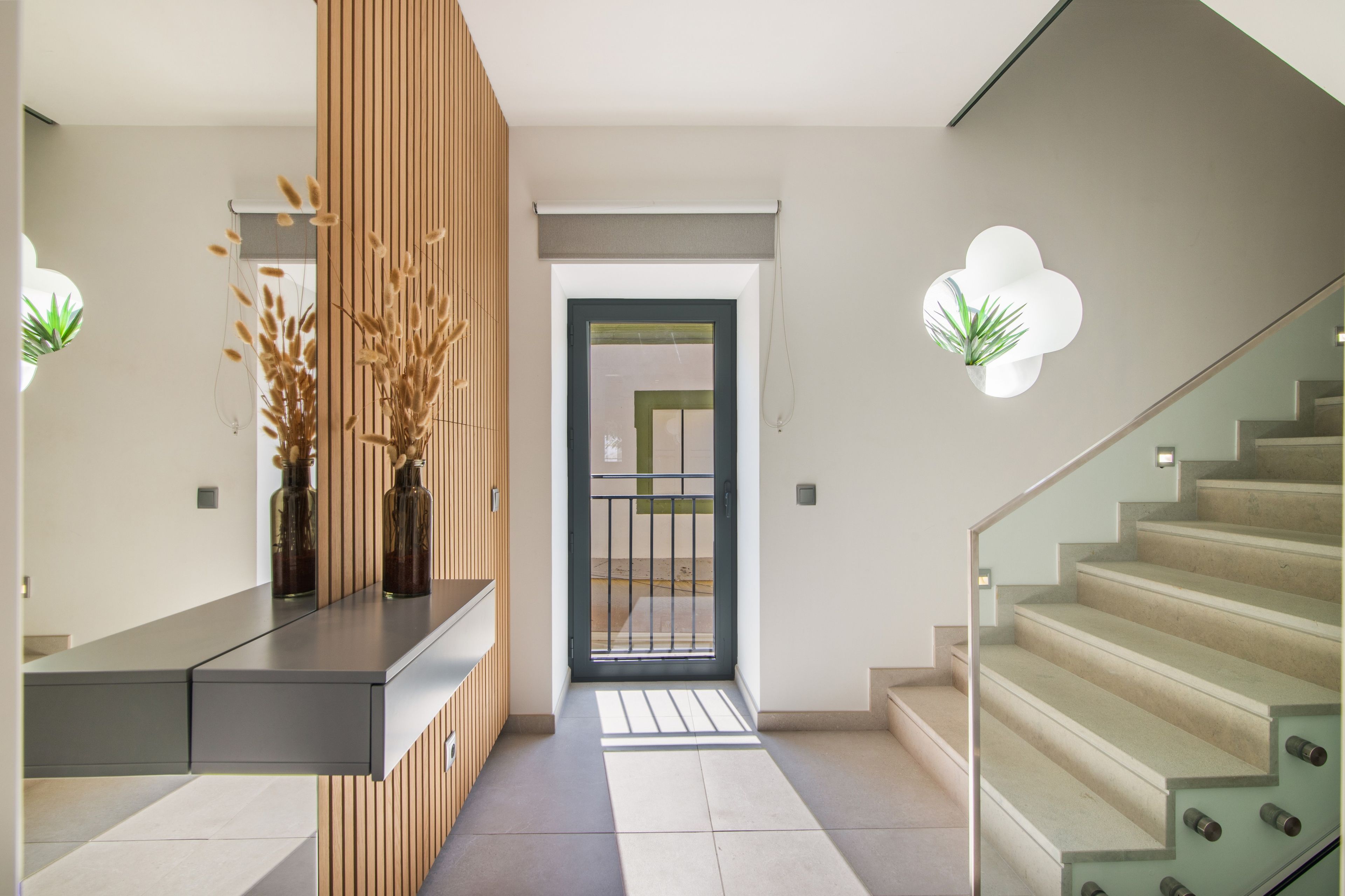 Un intérieur moderne comprenant un comptoir d’accueil, un escalier et une porte donnant sur une autre pièce.