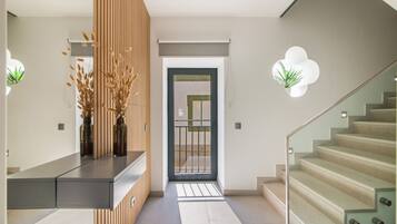 Un intérieur moderne comprenant un comptoir d’accueil, un escalier et une porte donnant sur une autre pièce.