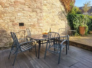 A patio with a stone wall, metal chairs, a table, and potted plants. - Court Hill Haven,
A wonderful base for your Swanage stay. (Swanage)