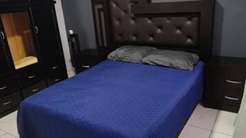 Une chambre à coucher avec un lit, une armoire et une table de chevet.