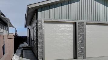 A residential garage with a stone accent wall and a clear driveway.
