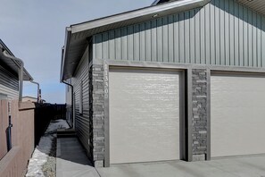 A residential garage with a stone accent wall and a clear driveway.