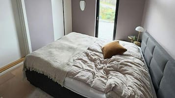 Un dormitorio con cama, ventana y puerta.