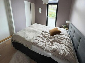 A bedroom with a bed, a window, and a door. - Fjord Idyll – Peace, Nature & Views (Vestland)