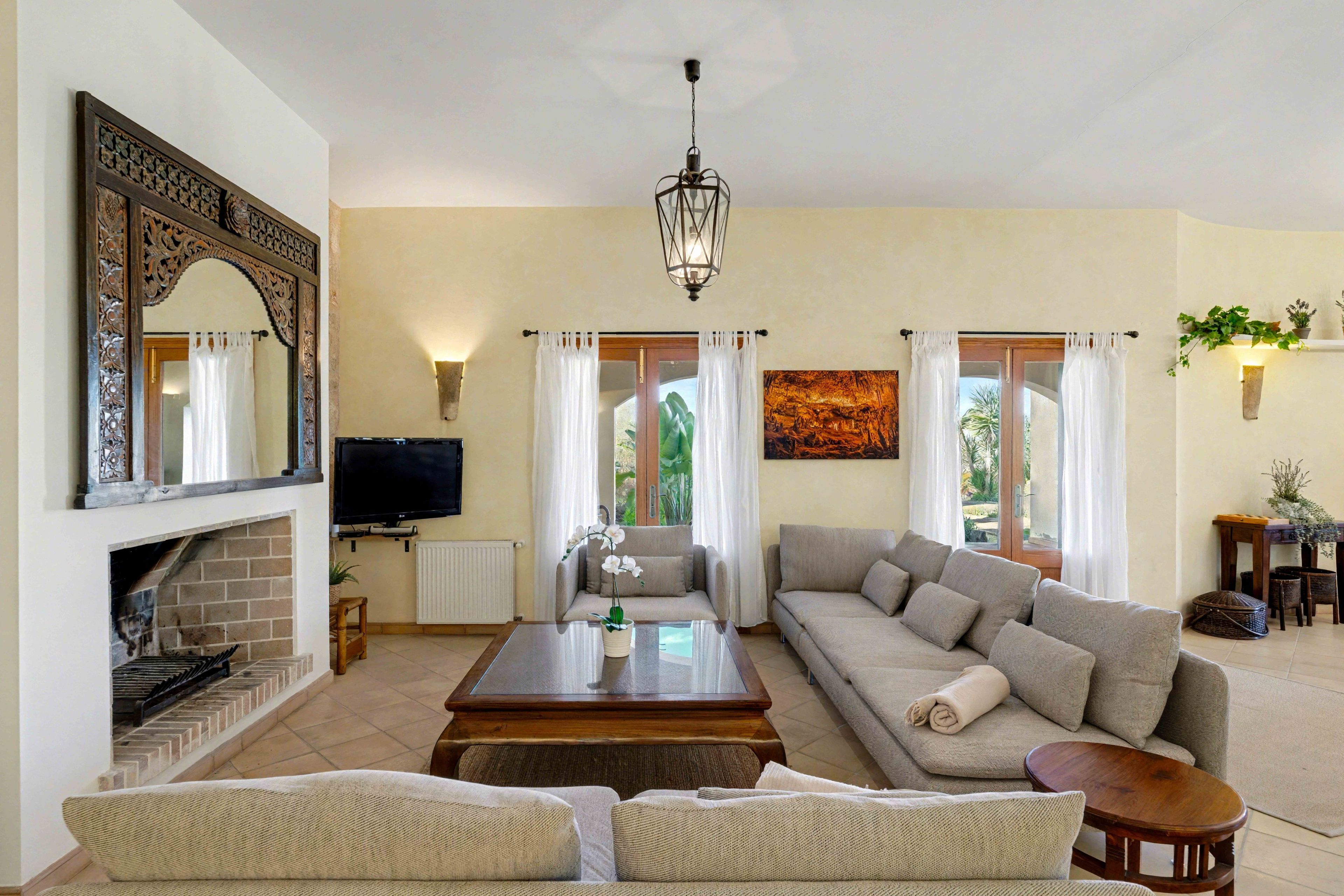 A living room with a fireplace, sofa, coffee table, and a television.